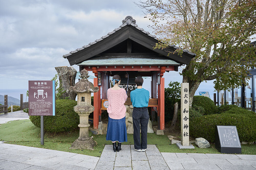 レインボーライン山頂公園の和合神社でお参りする20代女性二人